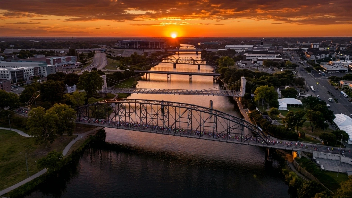 Aerial view of runners crossing a Waco bridge over the Brazos River at sunset