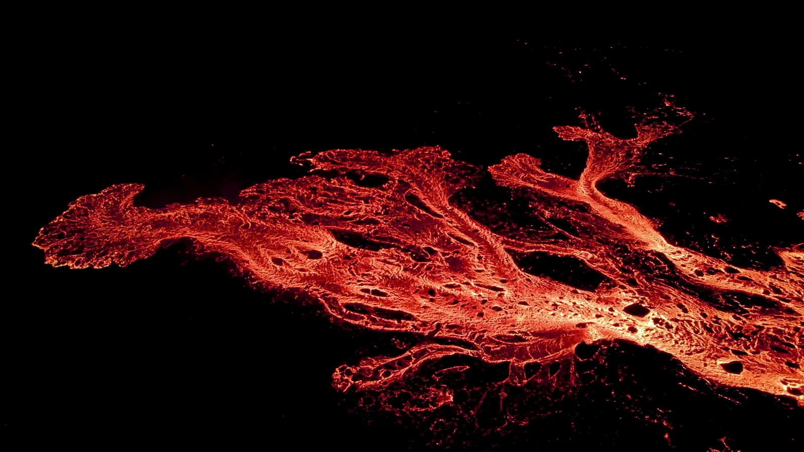 Glowing lava river branching across dark volcanic ground, from the Zavila Studio hero film